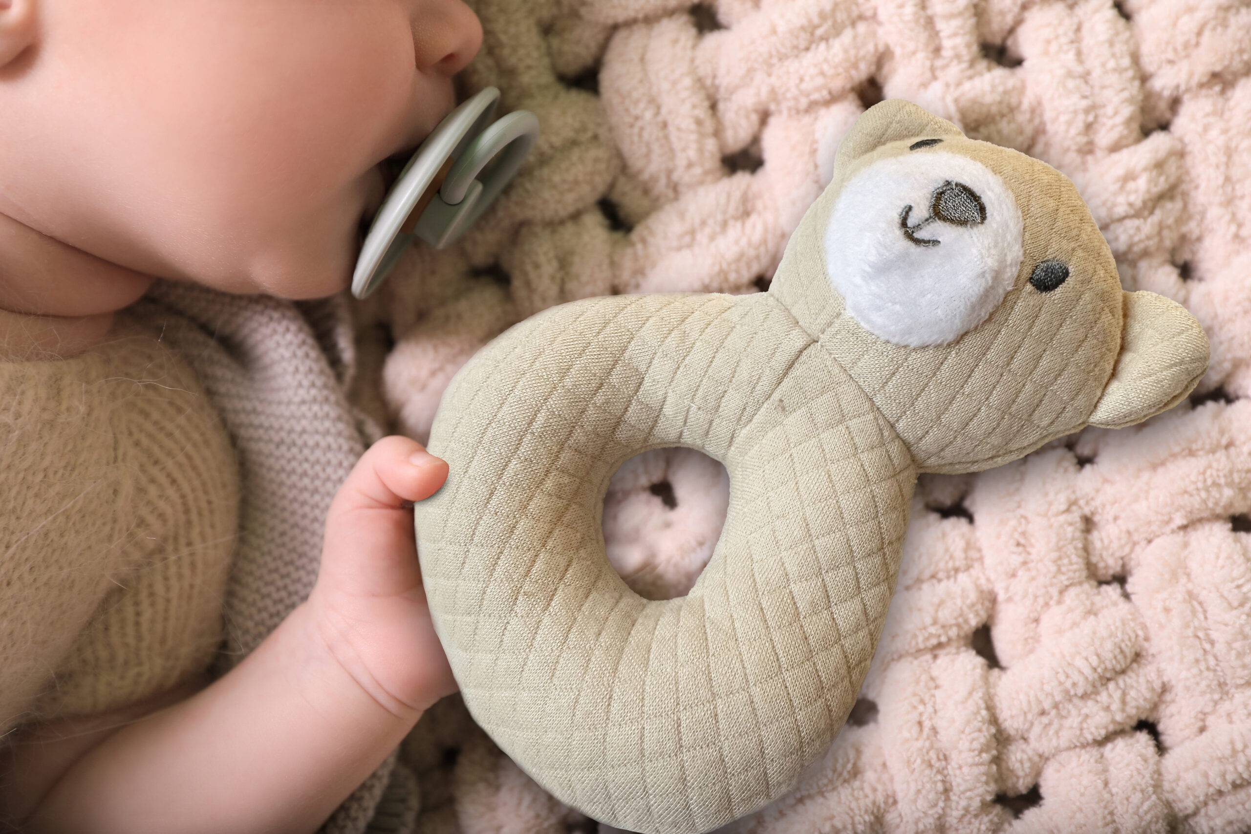 Baby with a Cribmates plush ring toy