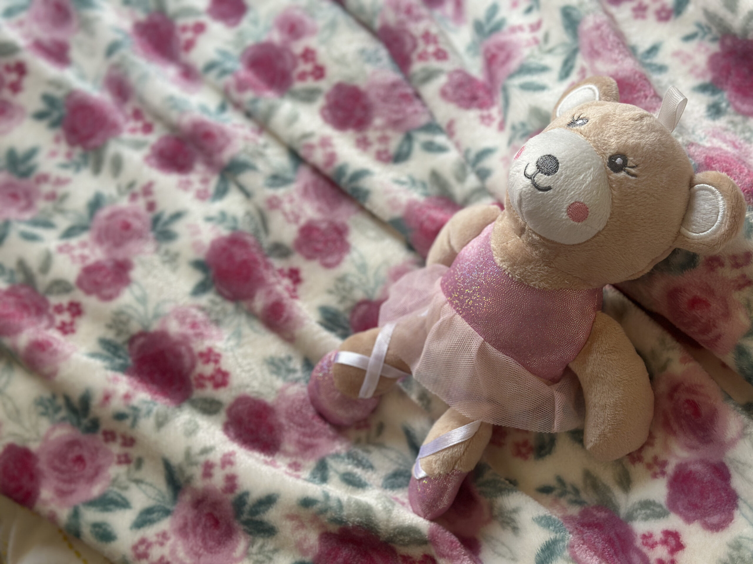 Petite l’amour plush bear on a floral blanket
